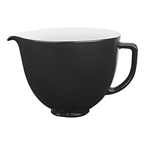 A matte black ceramic mixing bowl with a white interior and handle.