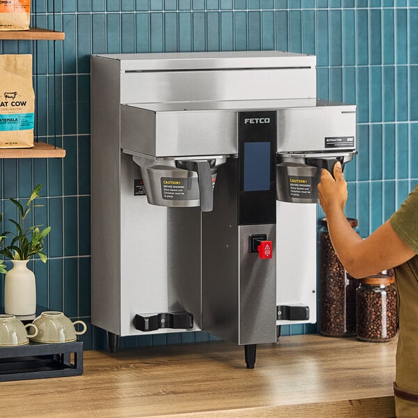 A woman using a Fetco CBS-2232 coffee machine.