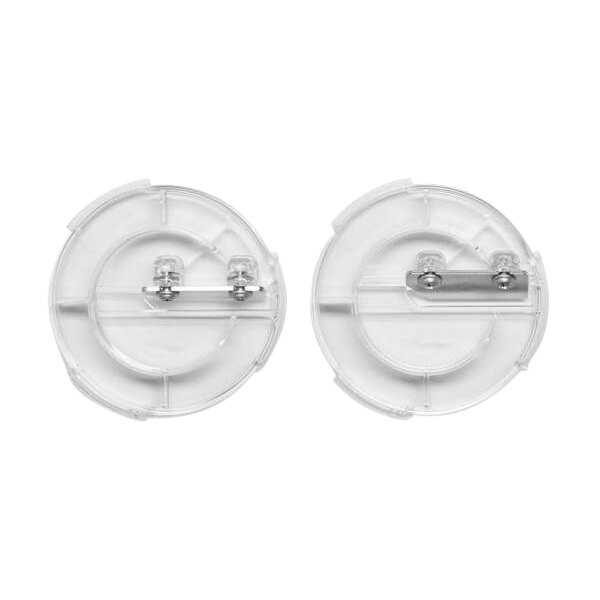 Two clear plastic buttons with metal clips on a white circular object with two small round blades inside.