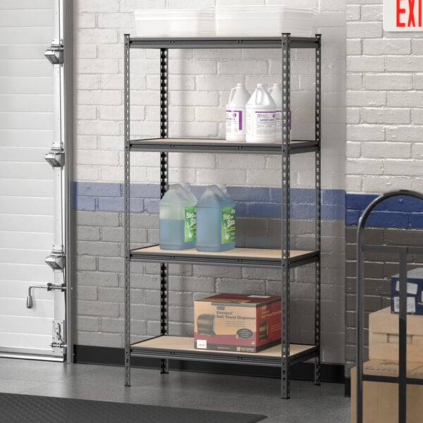 A Lavex black metal boltless shelving unit holding containers on particleboard shelves.