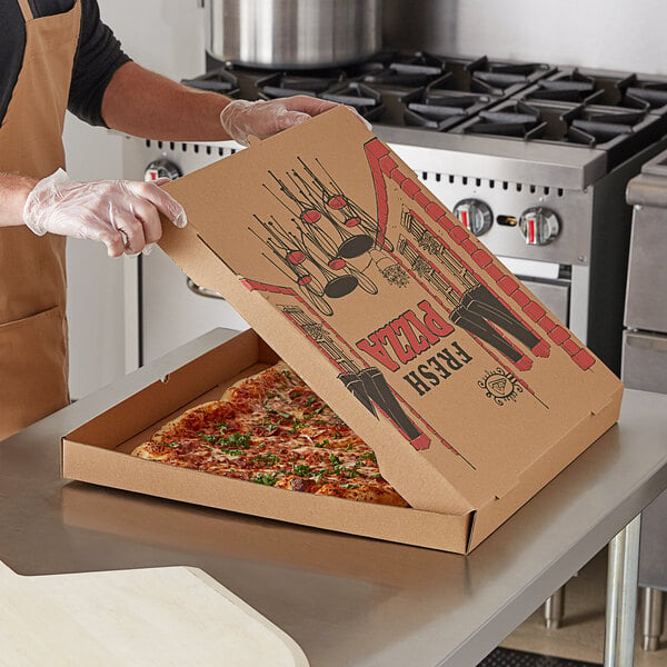 A person in an apron holding a Kraft corrugated pizza box with a pizza inside.