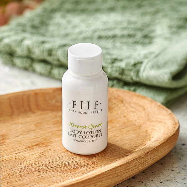 A white FarmHouse Fresh bottle of body lotion on a wooden surface.
