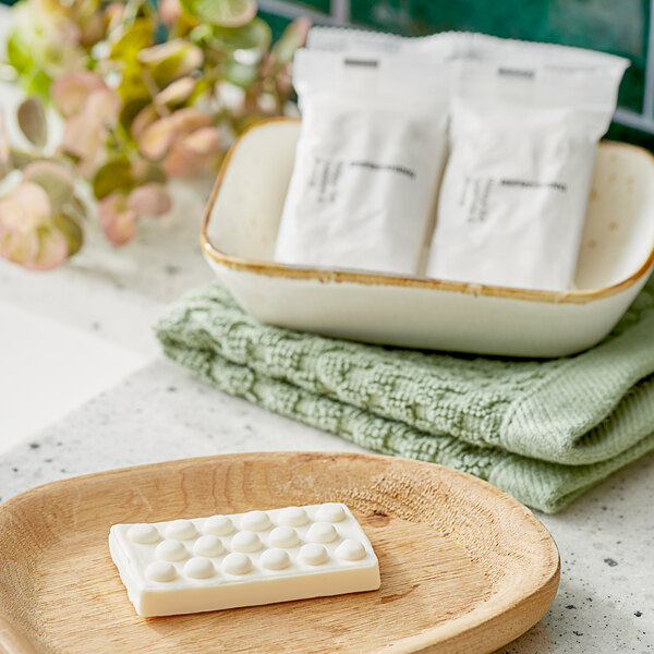 A white rectangular soap bar with circles on it in a grey wrapper.