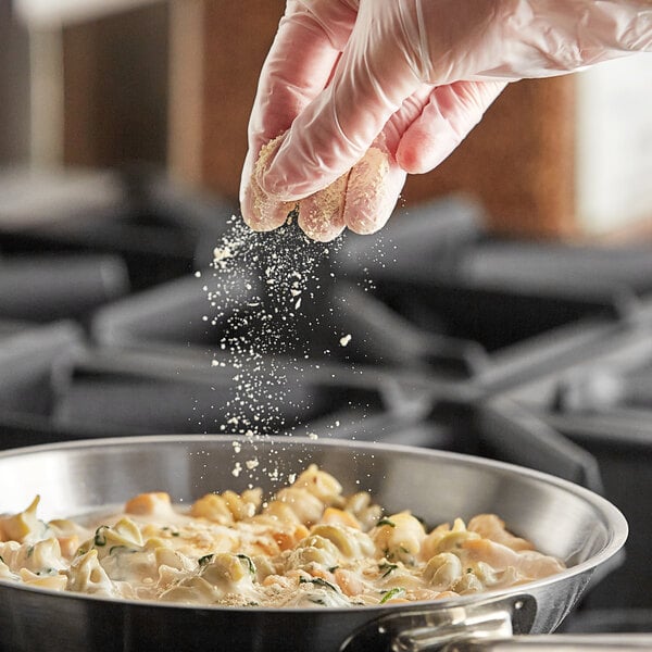 A person pouring Regal Organic Garlic Powder onto food.