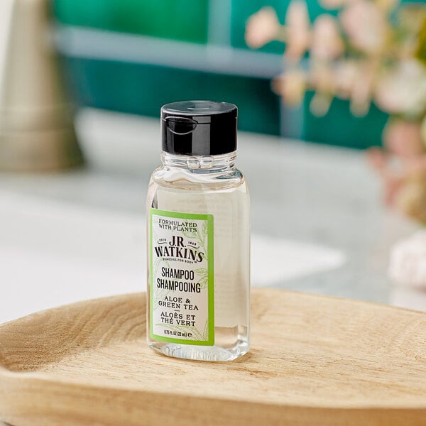 A bottle of JR Watkins Aloe and Green Tea Shampoo on a wooden tray.