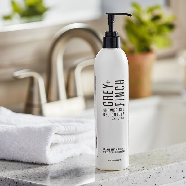 A white bottle of Grey + Finch DoveLok Crisp Air shower gel on a counter.