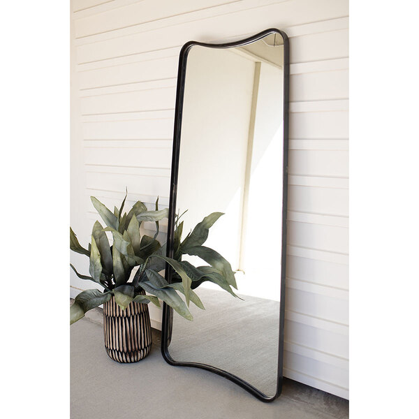 A Kalalou leaning mirror with a plant next to it.