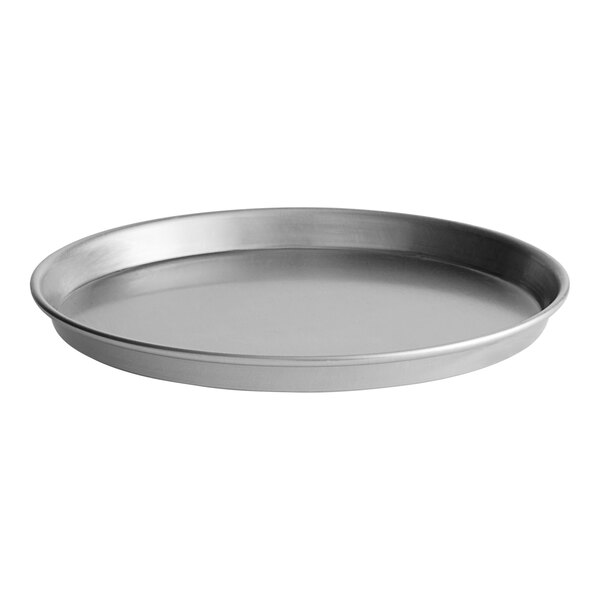 A round, silver aluminum deep dish pizza pan with a slightly raised edge.