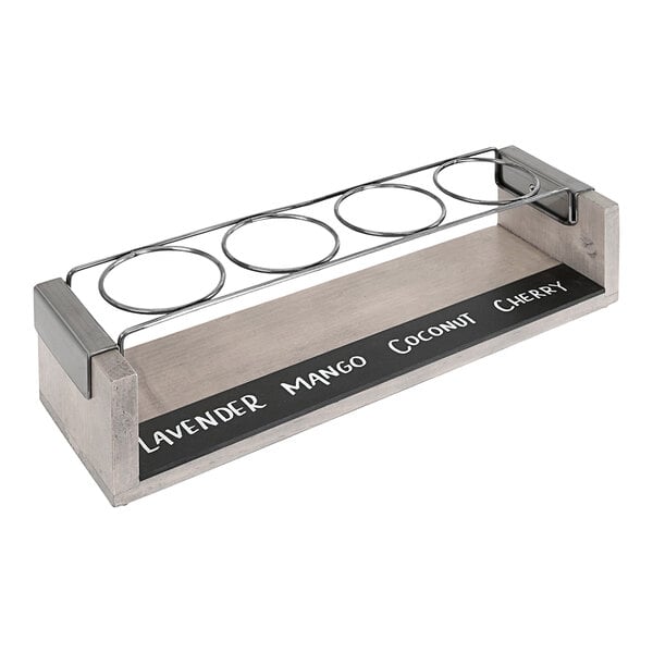 A gray-washed pine wood and metal Cal-Mil tasting flight holder with write-on surface for four glasses.