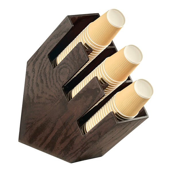 A Cal-Mil dark-stained oak wood countertop cup holder with three sections holding cups.