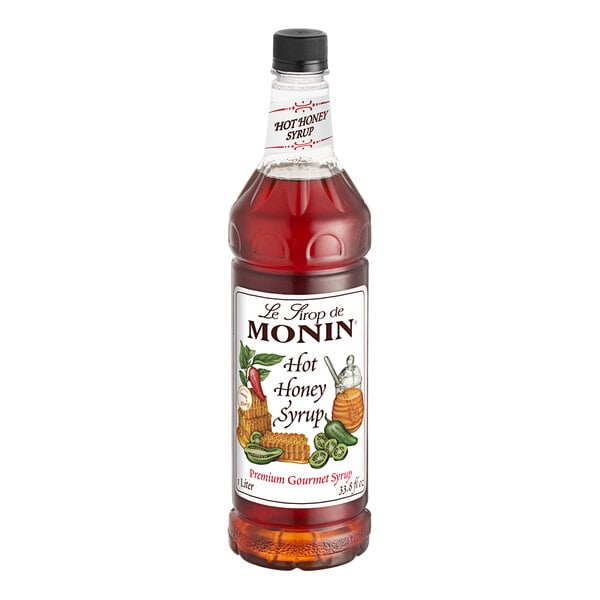 A Monin Premium Hot Honey Flavoring Syrup bottle with a label.