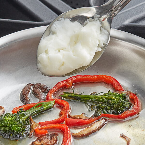 A spoon scooping Catania Spagna Coconut Oil from a pan.