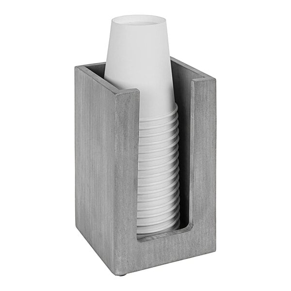 A Cal-Mil countertop cup holder with a stack of white cups in a wooden box.