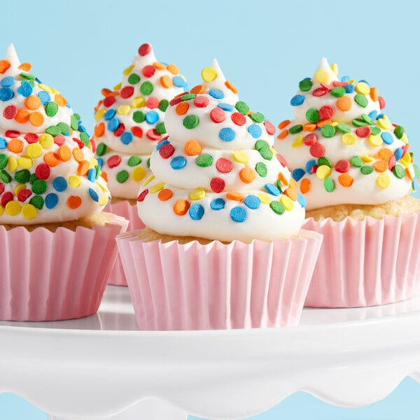 A cupcake in a pink wrapper with frosting and Adourne Bold Confetti Sequin Sprinkles.