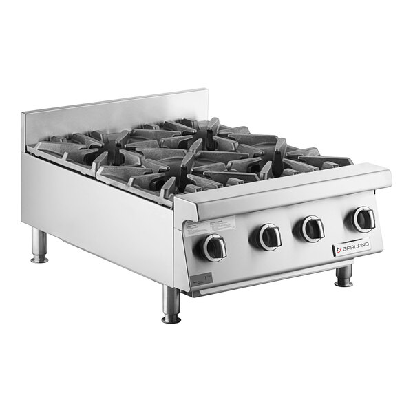 A Garland countertop gas range with four burners on a counter.