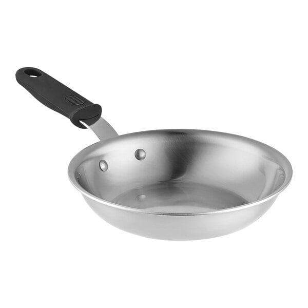 A Vollrath stainless steel frying pan with a black silicone handle.