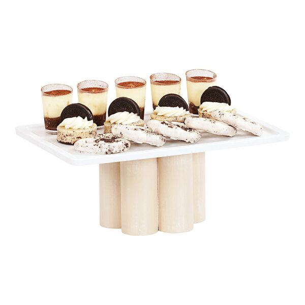 A Cal-Mil white-washed pine wood display riser holding a tray of desserts.