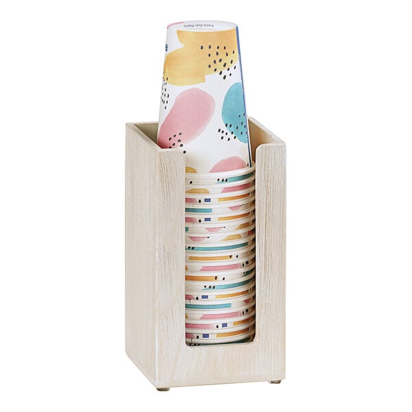 A Cal-Mil white-washed pine wood countertop cup holder with paper cups inside.