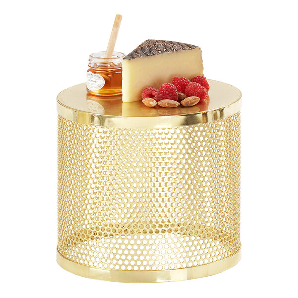 A Cal-Mil gold metal display riser with cheese and nuts on a table.