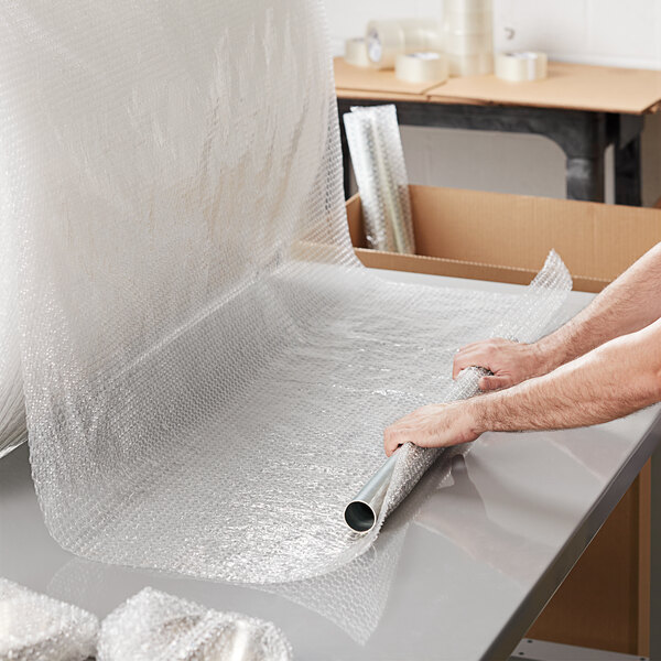 A person holding a roll of Lavex small bubble wrap.