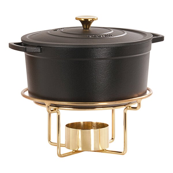 A black casserole in a gold metal stand.