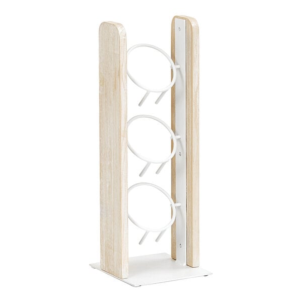 A white-washed wooden box with three white cylindrical stands inside.