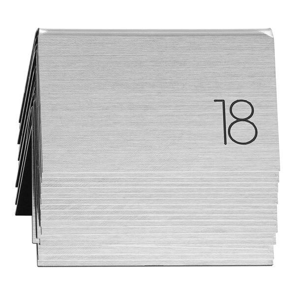 A stack of silver metal plates with black numbers from 1 to 25.