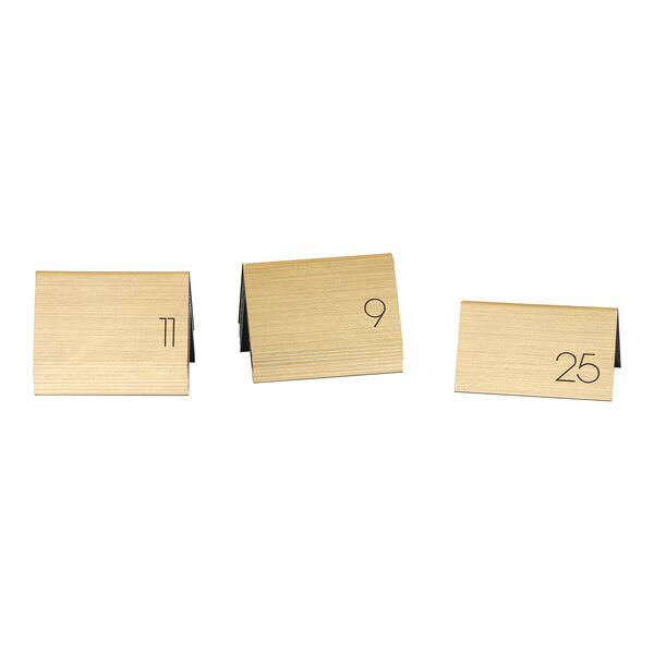 Gold metal Cal-Mil table number tents with black numbers.