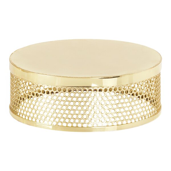 A gold metal circular display riser with holes.