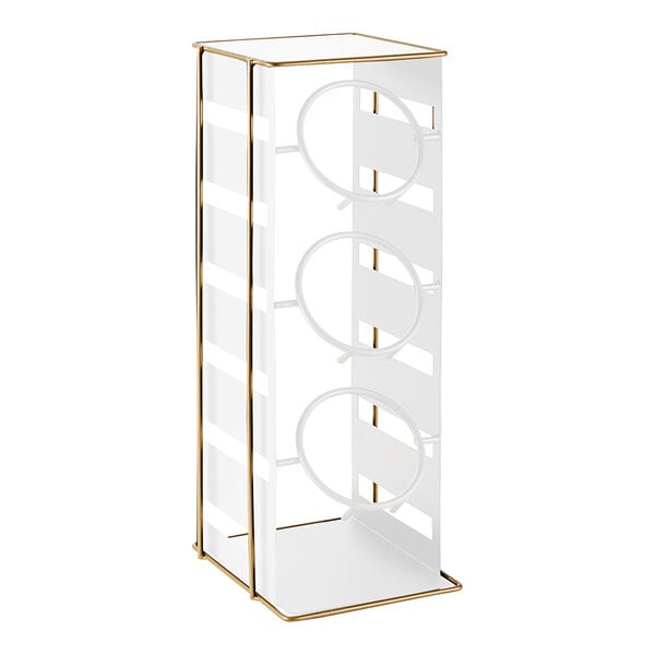 A white metal rack with three gold metal rings.