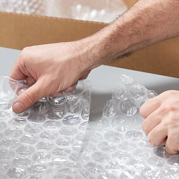 A person's hand holding a box of Lavex bubble wrap.