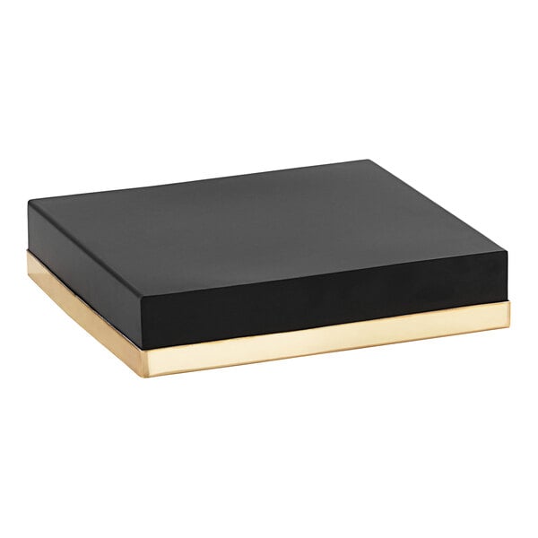 A black rectangular display riser with gold edges.