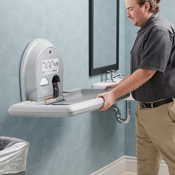 A man using a Koala Kare baby changing station.