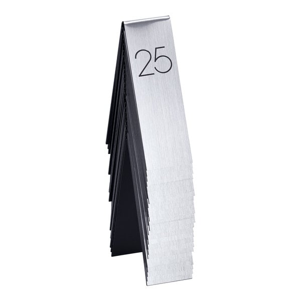 A stack of silver and black Cal-Mil metal table number tents with the number 25 on a white table.