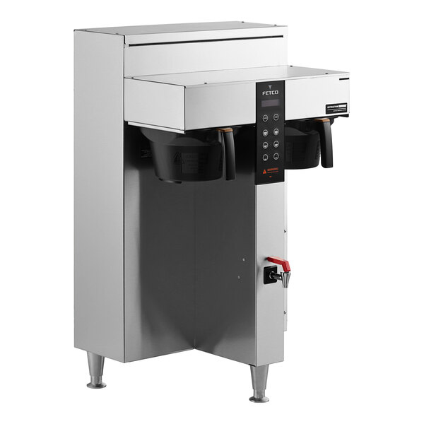 A Fetco commercial coffee machine on a counter with two plastic brew baskets.