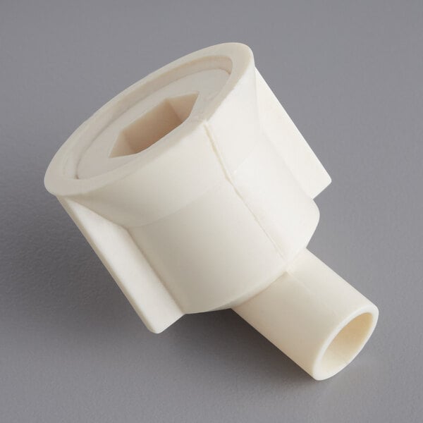 A close up of a white plastic Main Street Equipment evaporator drain fitting with a small hole in it.