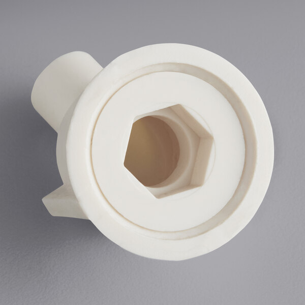 A white plastic Main Street Equipment evaporator drain fitting with a hexagon cut out.