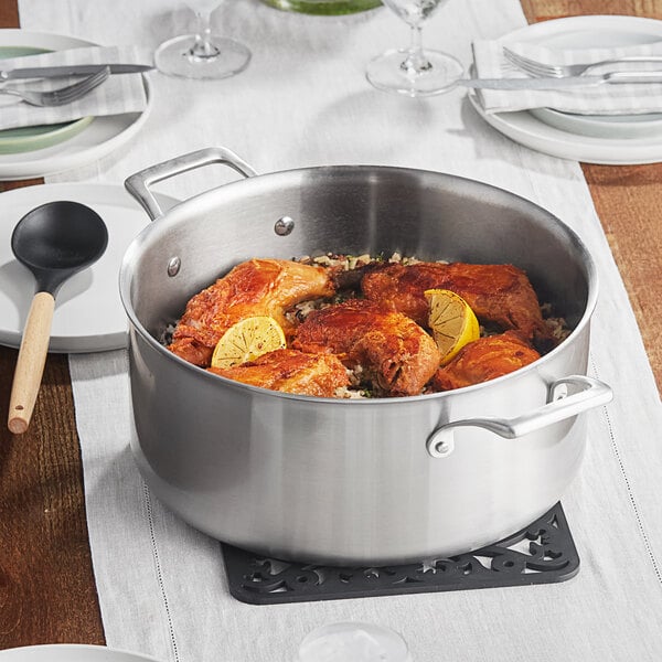 A Vigor Tri-Ply stainless steel brazier with chicken and rice on a table.