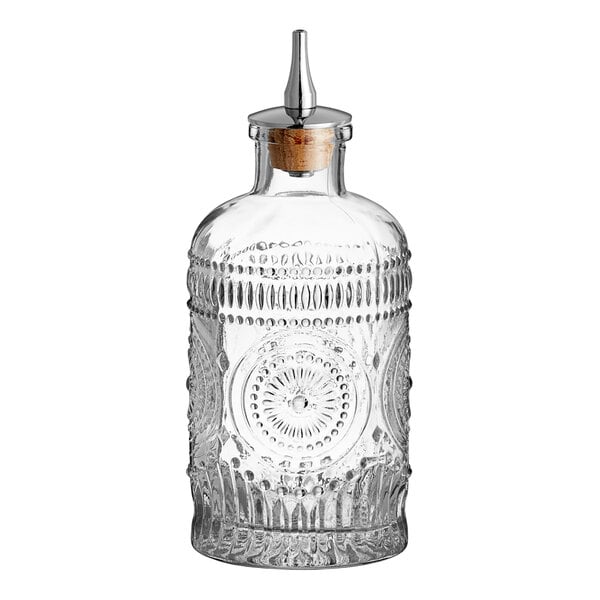 A clear glass Barfly Bitters Bottle with a metal stopper.