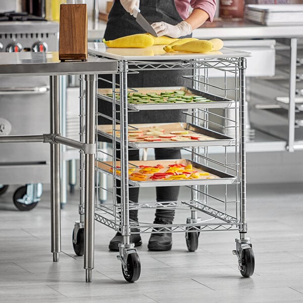 A woman uses a Regency wire rack with trays of fruit.