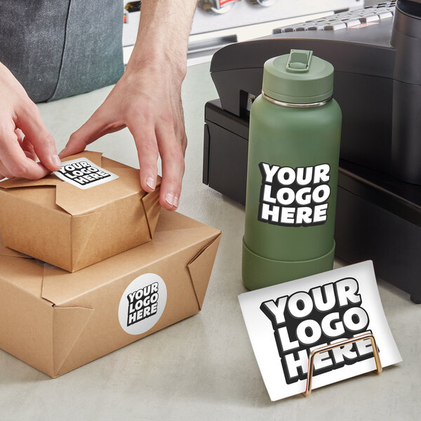 A person's hands putting a customizable square vinyl sticker on a box.