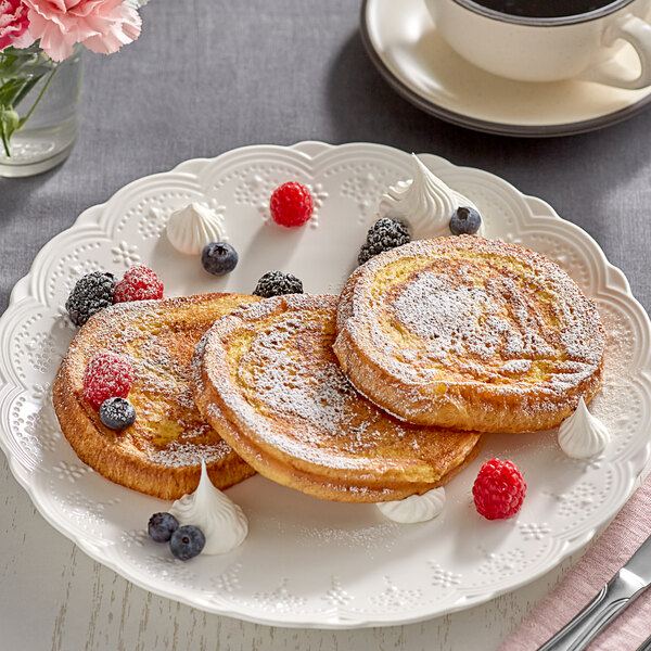 A plate with Krusteaz Cinnamon Swirl French Toast on it with raspberries and whipped cream.