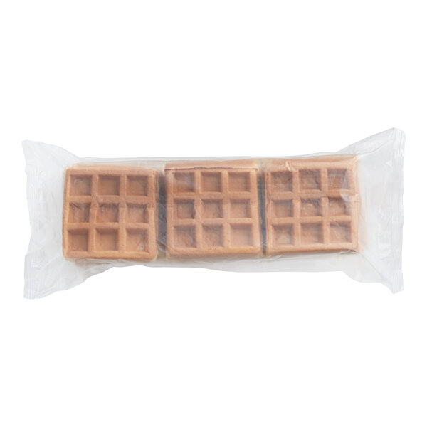 Three Krusteaz square whole grain Belgian waffles in plastic bags.