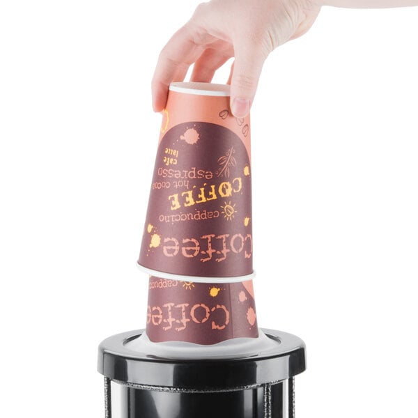 A hand using a San Jamar EZ-Fit cup dispenser to get a coffee cup.