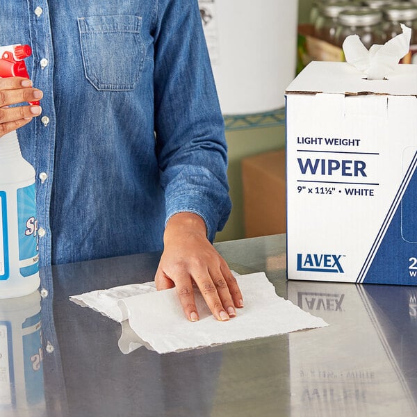 A person using a Lavex industrial wiper to clean a counter.
