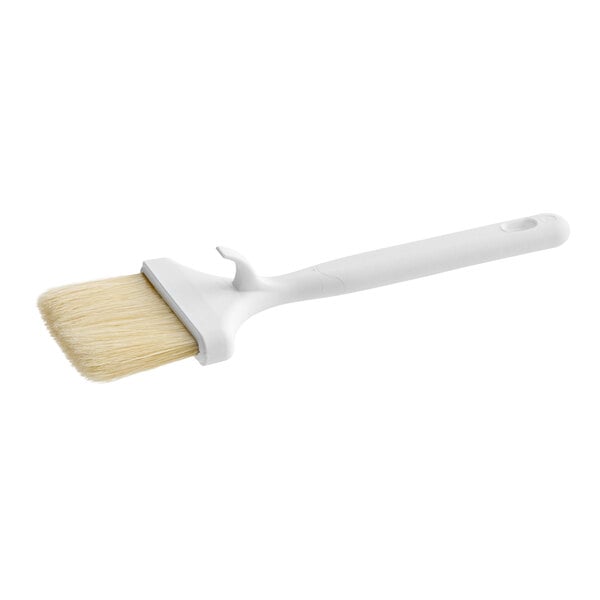 A white Carlisle Sparta Spectrum pastry brush with a wooden handle.