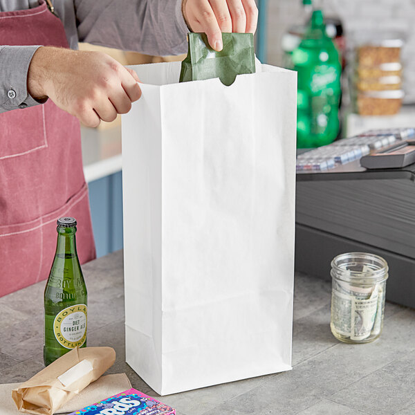 A person holding a white Choice paper bag.