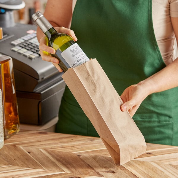 A woman holding a bottle of wine in a natural kraft paper bag.