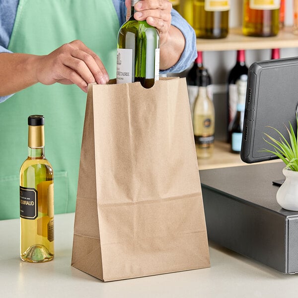 A person putting a green bottle into a ChoiceHD natural kraft paper bag.