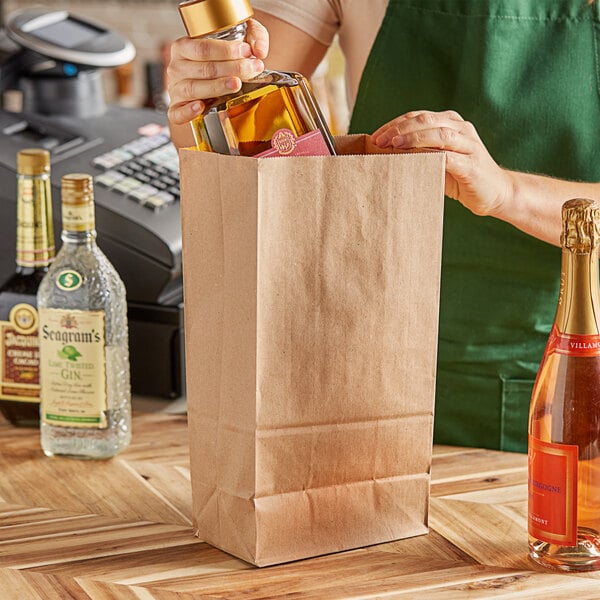 A woman holding a ChoiceHD brown paper bag with a bottle of liquor inside.